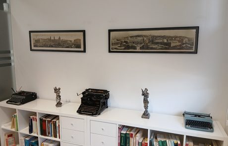 Fotografía a color del despacho de Cauce Abogados, un mueble con libros y objetos encima